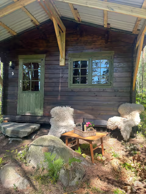 Sheepskin-stoler og bord ute foran hytten
