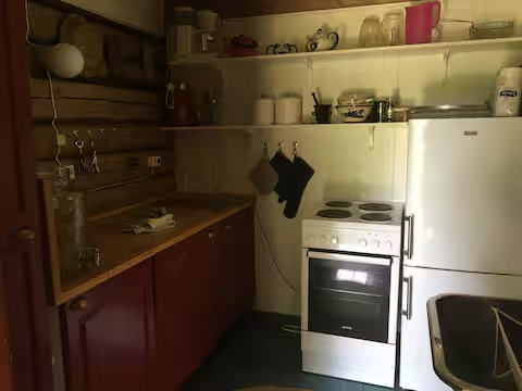 Kjøkken med komfyr og røde skap